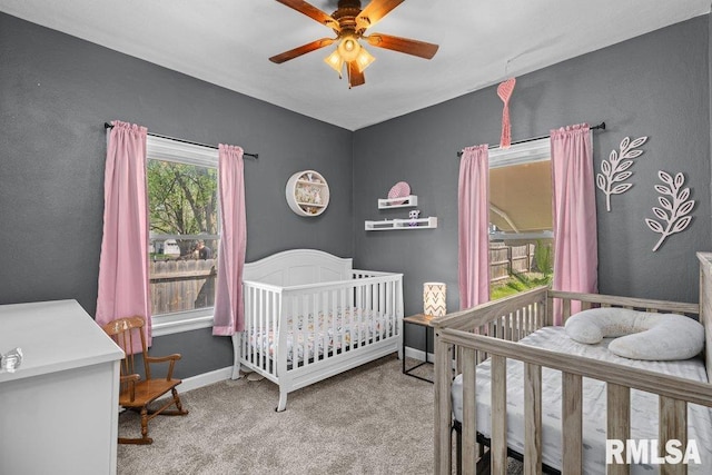 1117 S Ohio Ave, Davenport, IA 52802 - bedroom featuring a ceiling fan, carpet flooring, baseboards, and a crib