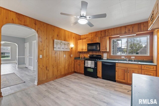 608 S Oakwood Ave, Geneseo, IL 61254 - kitchen featuring black appliances, a sink, wooden walls, a ceiling fan, and arched walkways