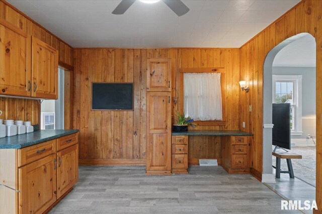 608 S Oakwood Ave, Geneseo, IL 61254 - kitchen featuring wooden walls, arched walkways, brown cabinets, ceiling fan, and dark countertops