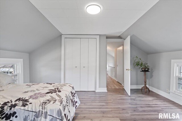 608 S Oakwood Ave, Geneseo, IL 61254 - bedroom featuring wood finished floors, vaulted ceiling, a closet, and baseboards