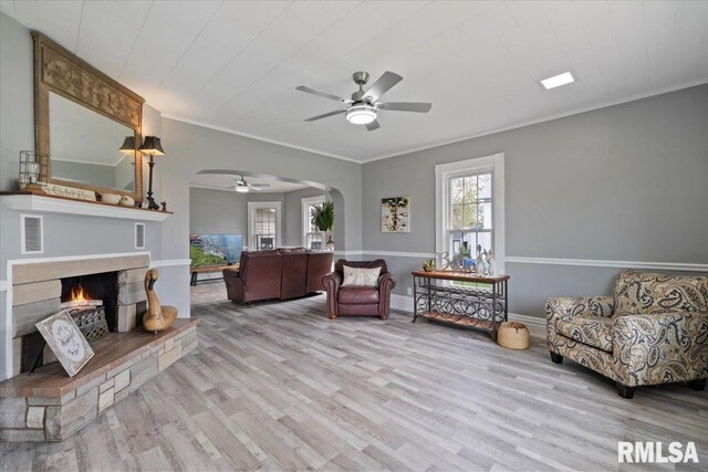 608 S Oakwood Ave, Geneseo, IL 61254 - living room with ceiling fan, arched walkways, wood finished floors, a warm lit fireplace, and ornamental molding