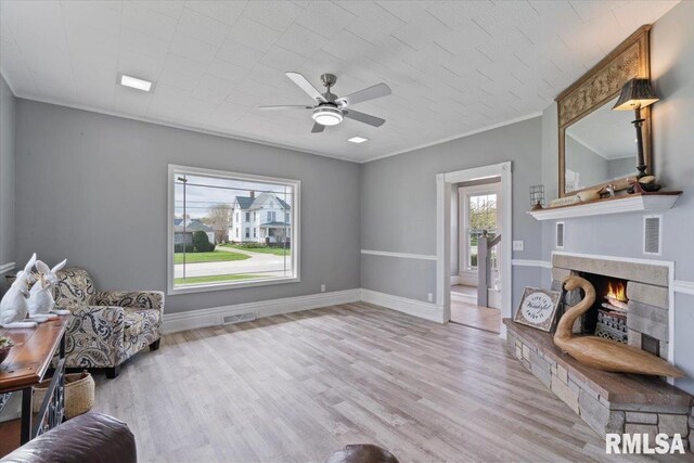 608 S Oakwood Ave, Geneseo, IL 61254 - living area with a warm lit fireplace, wood finished floors, ceiling fan, and baseboards