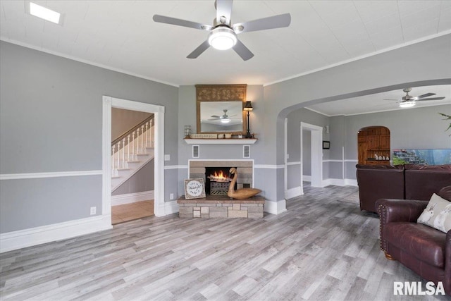 608 S Oakwood Ave, Geneseo, IL 61254 - living room with a ceiling fan, arched walkways, wood finished floors, a fireplace, and ornamental molding