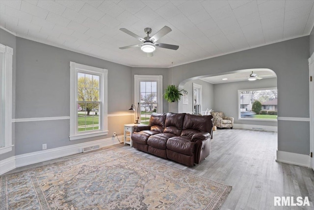 608 S Oakwood Ave, Geneseo, IL 61254 - living room featuring a ceiling fan, arched walkways, wood finished floors, crown molding, and baseboards