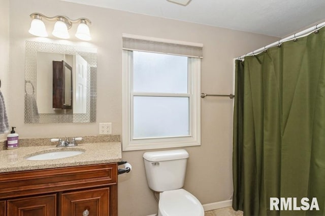 bathroom with toilet, vanity, and baseboards