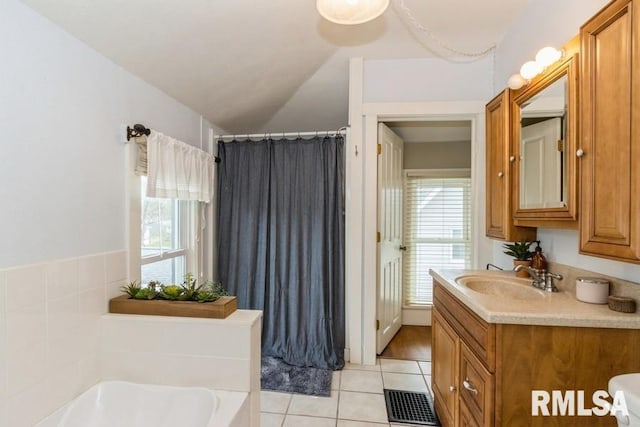 bathroom with a bath, a wealth of natural light, tile patterned floors, and visible vents