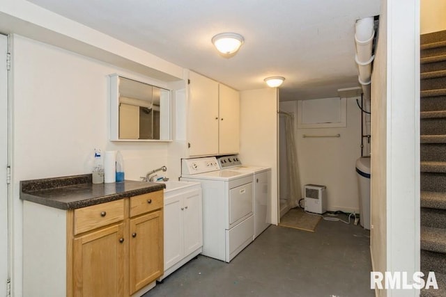 laundry area with a sink, independent washer and dryer, and cabinet space