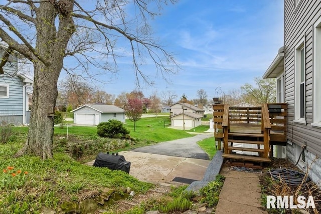 view of yard with a wooden deck, an outbuilding, and a residential view