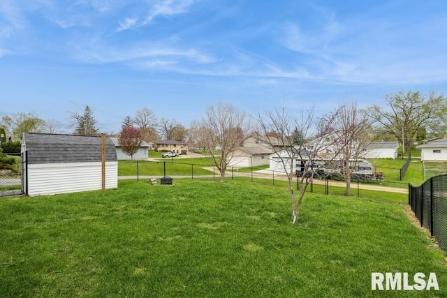 view of yard with a storage shed, a residential view, an outbuilding, and fence