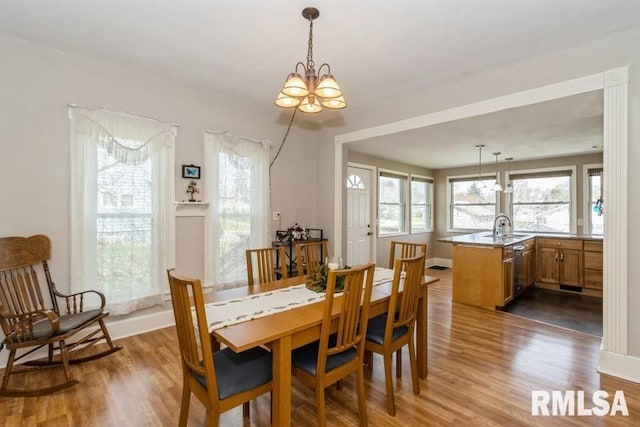 dining area featuring an inviting chandelier, wood finished floors, and plenty of natural light