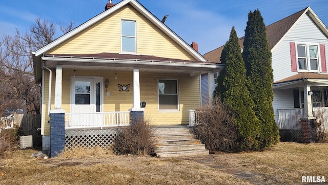 view of front facade featuring a chimney and a porch