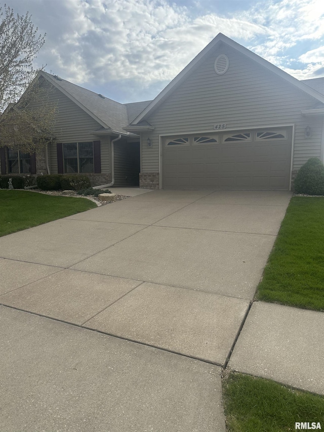 425 Kevin Rd, Blue Grass, IA 52726 - single story home with driveway, brick siding, and a garage