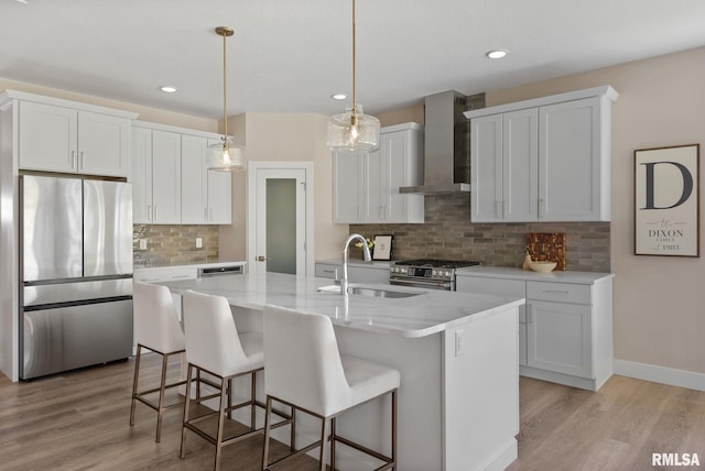 4048 Meadowlark Ct, Bettendorf, IA 52722 - kitchen featuring stainless steel appliances, wall chimney range hood, a kitchen bar, a sink, and light wood-type flooring