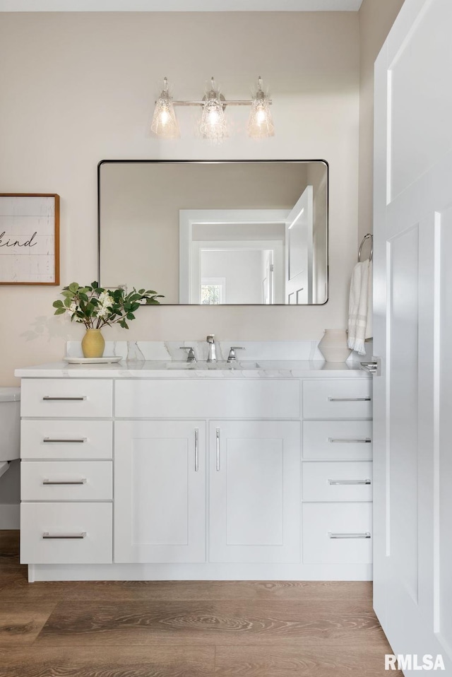 4048 Meadowlark Ct, Bettendorf, IA 52722 - bathroom featuring toilet, wood finished floors, and vanity