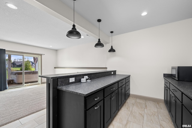 kitchen featuring baseboards, decorative light fixtures, dark countertops, and dark cabinets