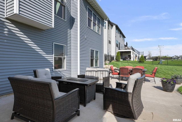 view of patio / terrace with fence and an outdoor living space with a fire pit