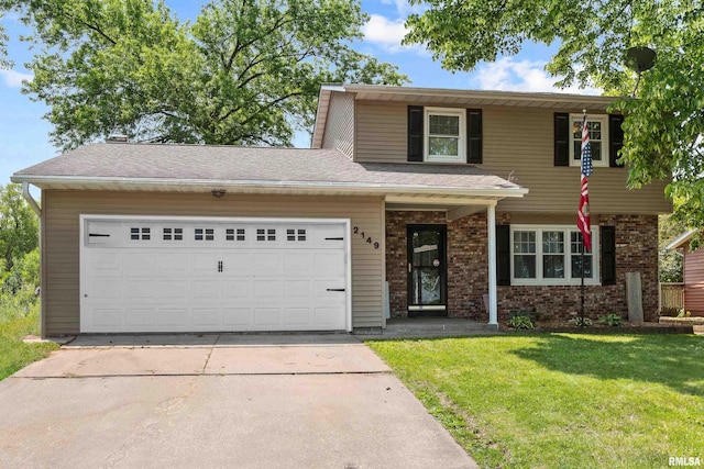 2149 W 30th St, Davenport, IA 52804 - traditional-style home featuring a front lawn, concrete driveway, an attached garage, and brick siding