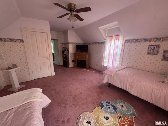 bedroom with lofted ceiling, wallpapered walls, a fireplace, carpet, and a ceiling fan