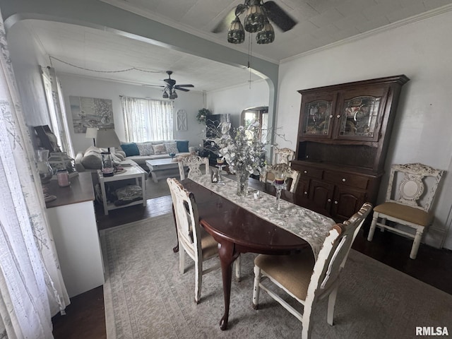 dining space with arched walkways, ceiling fan, and crown molding