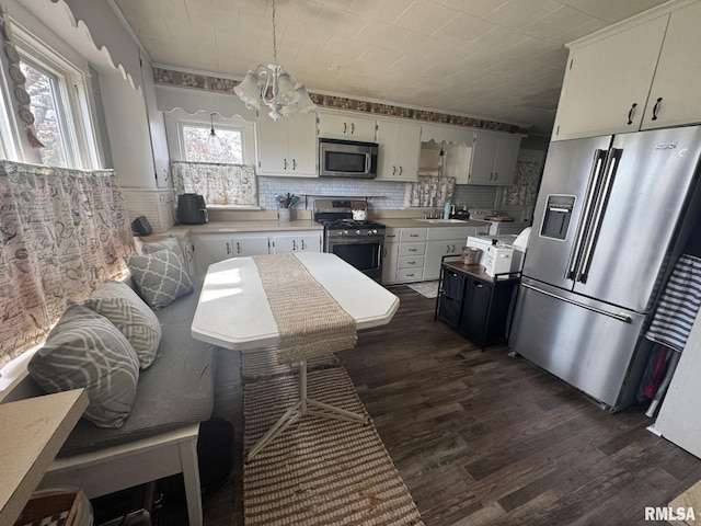 kitchen featuring ornamental molding, stainless steel appliances, and dark wood finished floors