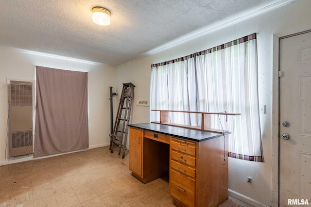 unfurnished office with ornamental molding, light floors, a textured ceiling, and a heating unit