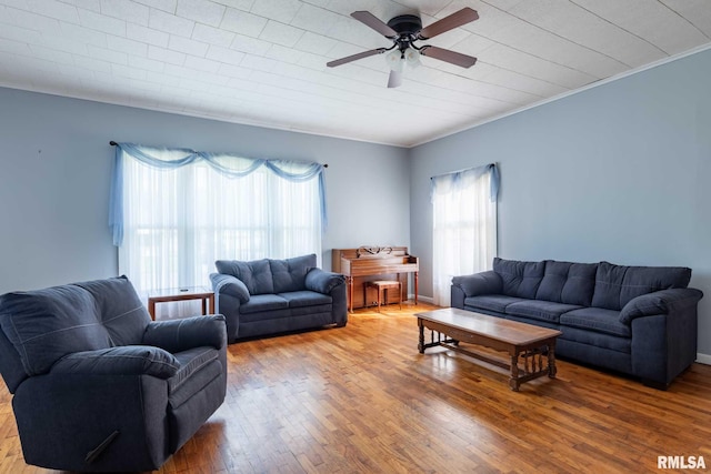 living area featuring a healthy amount of sunlight, ceiling fan, hardwood / wood-style flooring, and ornamental molding