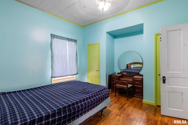bedroom featuring hardwood / wood-style floors and baseboards