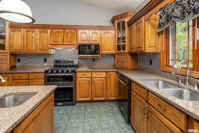 kitchen with black appliances, a sink, brown cabinets, and lofted ceiling