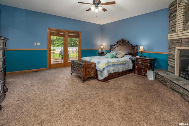 carpeted bedroom featuring a stone fireplace, ceiling fan, visible vents, and access to outside