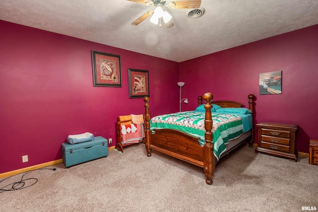 carpeted bedroom with a textured ceiling, visible vents, ceiling fan, and baseboards
