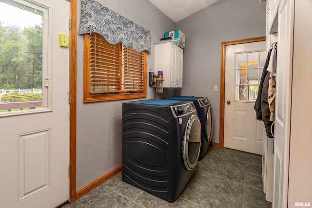 clothes washing area with baseboards, separate washer and dryer, and cabinet space