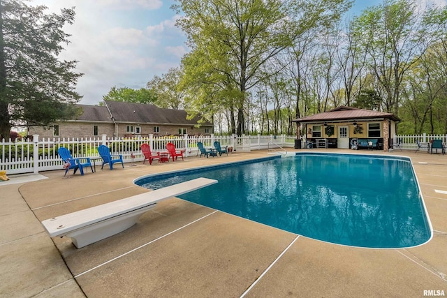 view of pool featuring a diving board, fence, a fenced in pool, a patio, and a ceiling fan