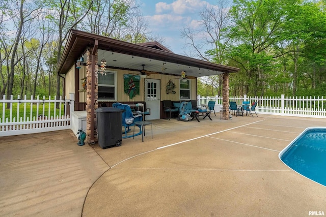 view of patio featuring fence, ceiling fan, and a fenced in pool