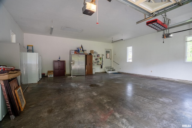 garage featuring a garage door opener, freestanding refrigerator, and baseboards