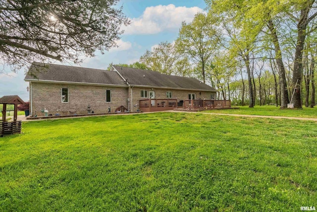 back of house featuring a lawn, a deck, a gazebo, and brick siding