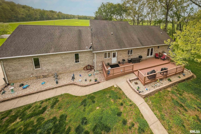 back of house with an outdoor living space, a deck, a yard, and brick siding