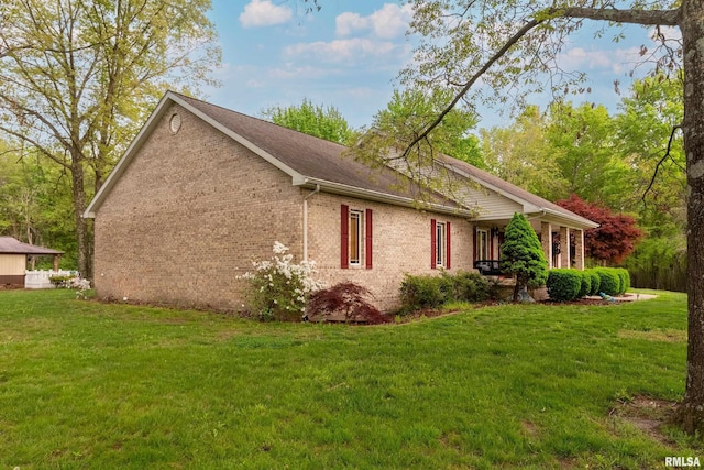 view of side of property featuring a yard and brick siding