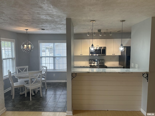 1000 N Almond St, Carbondale, IL 62901 - kitchen with appliances with stainless steel finishes, plenty of natural light, light stone countertops, and baseboards