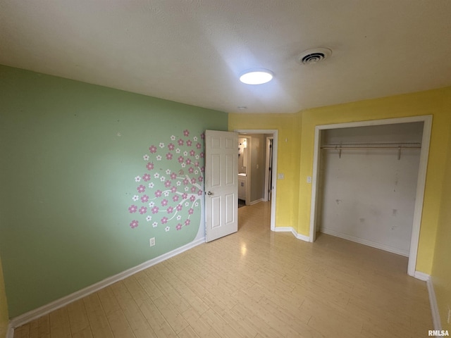 1000 N Almond St, Carbondale, IL 62901 - unfurnished bedroom with a closet, visible vents, wood finished floors, and baseboards