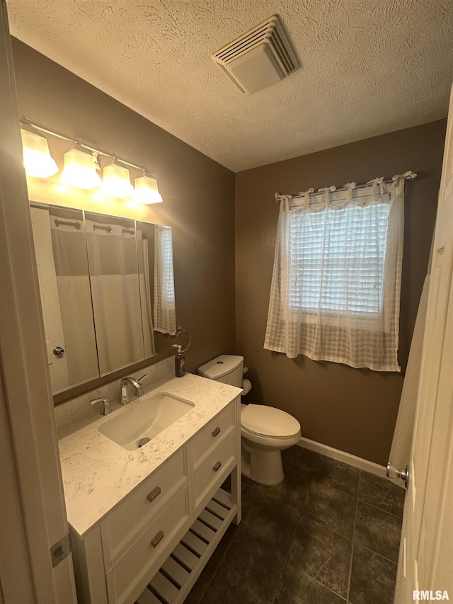 1000 N Almond St, Carbondale, IL 62901 - bathroom featuring a textured ceiling, visible vents, baseboards, toilet, and vanity