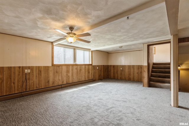12323 Niabi Zoo Rd, Coal Valley, IL 61240 - unfurnished room featuring stairway, a wainscoted wall, a ceiling fan, wood walls, and carpet floors