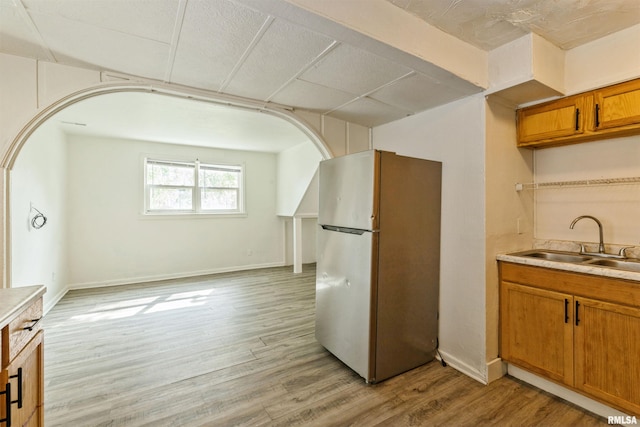 737/739 24th St, East Moline, IL 61244 - kitchen featuring freestanding refrigerator, brown cabinetry, a sink, light wood-style floors, and light countertops