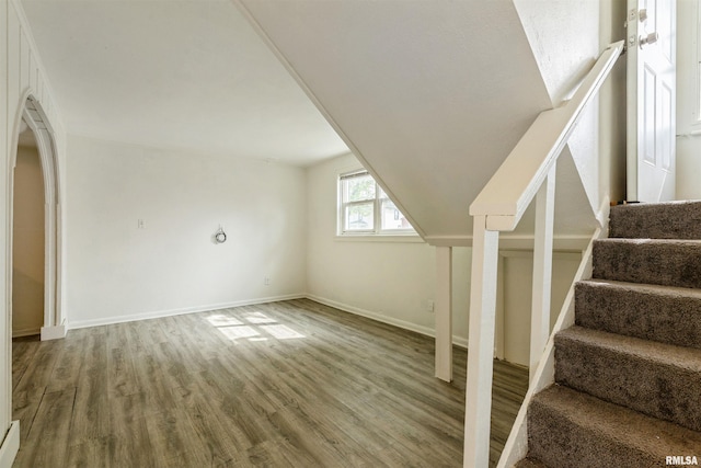 737/739 24th St, East Moline, IL 61244 - additional living space featuring wood finished floors, baseboards, arched walkways, vaulted ceiling, and stairs