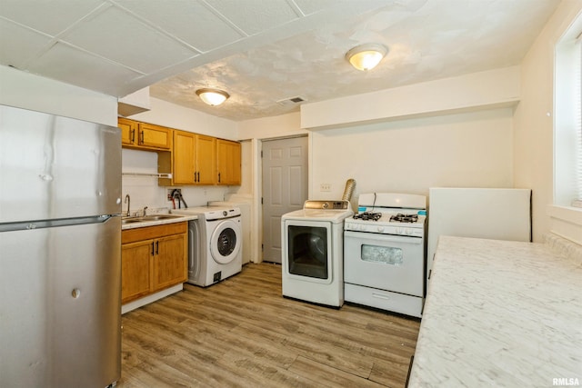 737/739 24th St, East Moline, IL 61244 - kitchen featuring freestanding refrigerator, a sink, white gas stove, light wood-style floors, and light countertops