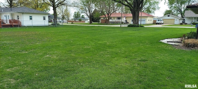view of yard with fence, concrete driveway, and a residential view