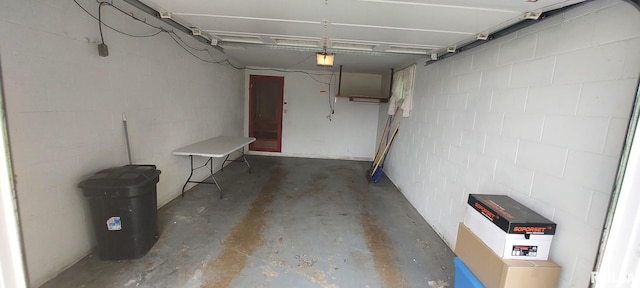garage featuring a garage door opener and concrete block wall
