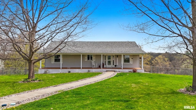 view of front facade with covered porch, fence, a shingled roof, and a front lawn
