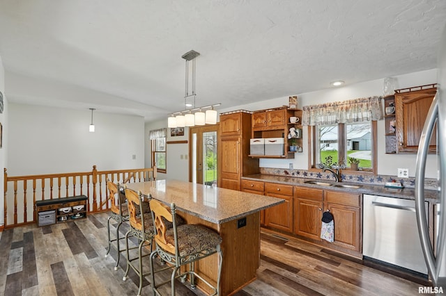kitchen with dark wood finished floors, brown cabinetry, open shelves, dishwasher, and a sink