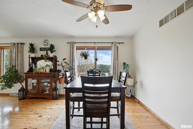 dining room with visible vents, a ceiling fan, a wealth of natural light, and light wood-style floors