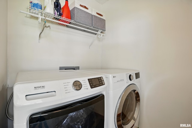 clothes washing area featuring washer and clothes dryer and laundry area